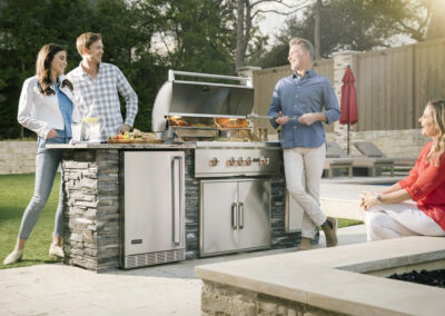 friends around outdoor kitchen with grill